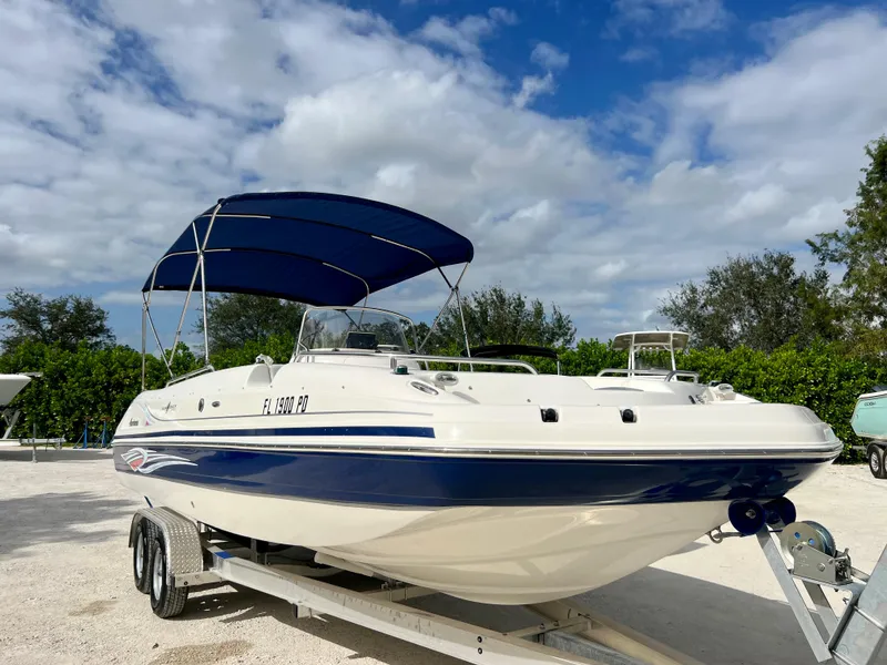 Slide: The Image of 2011 Hurricane 231 boat with blue canopy on trailer under cloudy sky. - 5