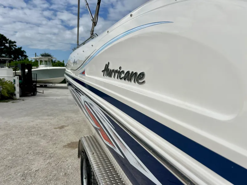 Slide: The Image of 2011 Hurricane 231 boat close-up with logo, parked on a sunny day. - 8