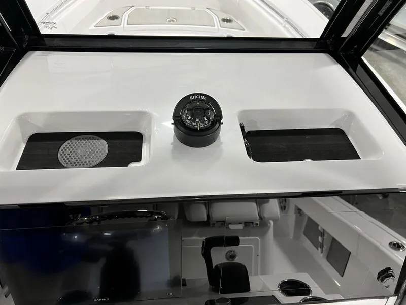 Slide: The Image of 2024 Sportsman Masters 267OE Bay boat dashboard with compass and storage compartments. - 22