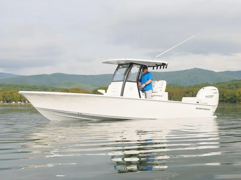 Slide: The Image of 2024 Sportsman Masters 267OE Bay boat on calm water with scenic mountain backdrop. - 3