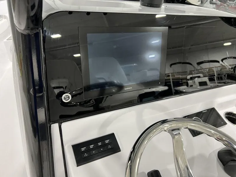 Slide: The Image of 2024 Sportsman Masters 267OE Bay boat dashboard with Garmin display and steering wheel. - 42