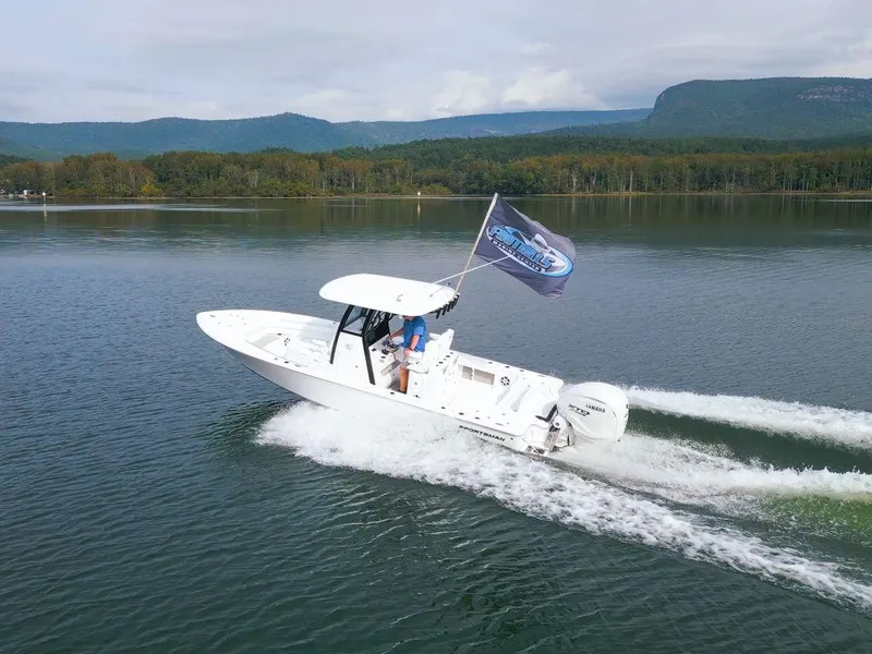 Slide: The Image of 2024 Sportsman Masters 267OE Bay boat cruising on a scenic lake. - 5