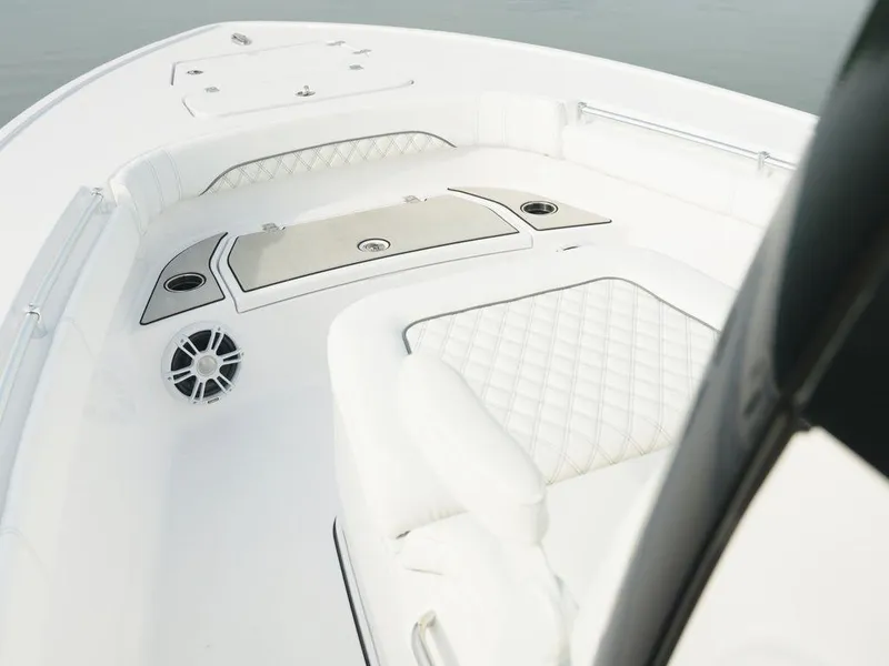 Slide: The Image of 2024 Sportsman Masters 267OE Bay boat interior with white cushioned seating and sleek design. - 8
