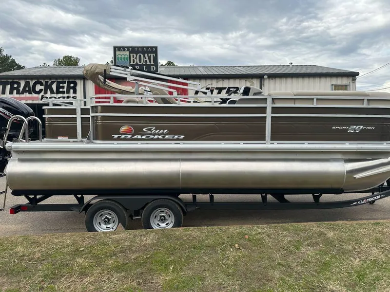 The Image of 2024 Sun Tracker SportFish 20 DLX pontoon boat on trailer at dealership. - 0