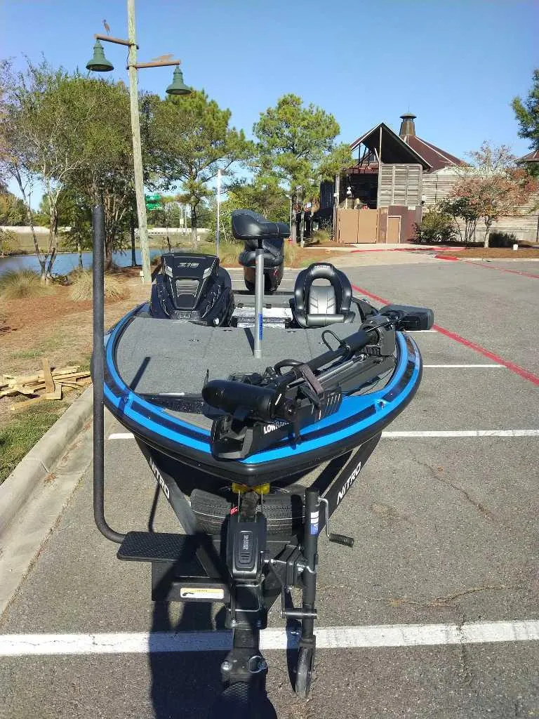 Slide: The Image of 2024 Nitro Z19 Pro fishing boat parked in a lot near a lake. - 7