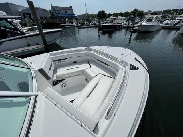 Slide: The Image of 2021 Blackfin 252 DC boat docked at a marina with spacious seating area. - 16
