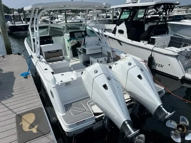 Slide: The Image of 2021 Blackfin 252 DC boat docked with twin outboard engines. - 2
