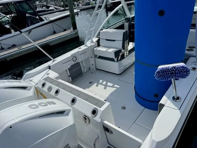 Slide: The Image of 2021 Blackfin 252 DC boat interior with dual outboard engines at a marina. - 4