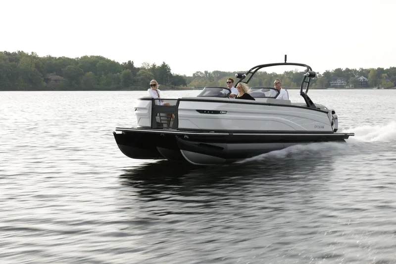 Slide: The Image of 2024 Sylvan G5 CLZ DC pontoon boat cruising on a lake with passengers. - 12