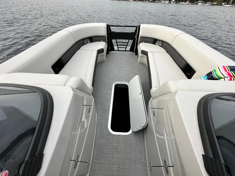 Slide: The Image of 2024 Sylvan G5 CLZ DC boat interior with open storage compartment on a lake. - 13