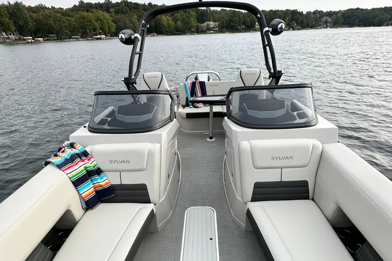 Slide: The Image of 2024 Sylvan G5 CLZ DC boat on a lake with plush seating and colorful towels. - 15