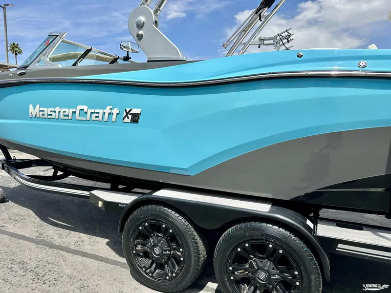 Slide: The Image of 2018 MasterCraft XT22 boat in blue on a trailer. - 2