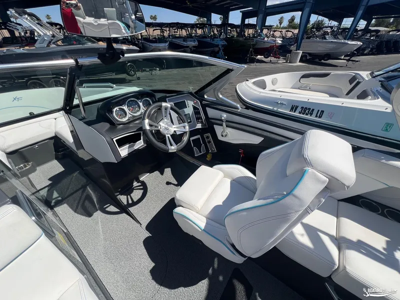 Slide: The Image of 2018 MasterCraft XT22 boat interior with steering wheel and dashboard, docked at marina. - 6