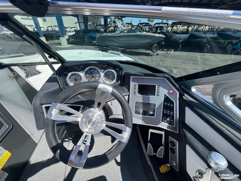 Slide: The Image of 2018 MasterCraft XT22 boat dashboard with steering wheel and control panel. - 7
