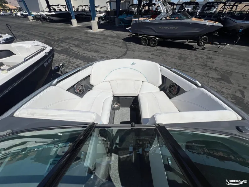 Slide: The Image of 2018 MasterCraft XT22 boat with white interior seating, docked among other boats. - 9