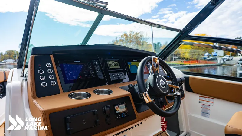 Slide: The Image of 2024 Chaparral 300 OSX boat dashboard with modern controls and scenic marina view. - 20