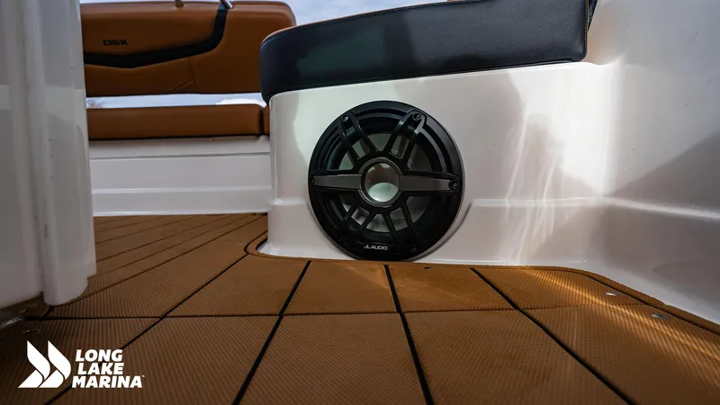 Slide: The Image of 2024 Chaparral 300 OSX boat interior with JL Audio speaker and teak flooring. - 26