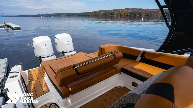 Slide: The Image of 2024 Chaparral 300 OSX boat with tan seating, dual engines, on a serene lake. - 8