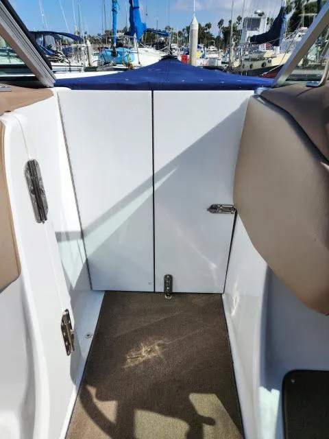 Slide: The Image of 2008 Cobalt 252 boat interior with closed cabin door and beige seating. - 15