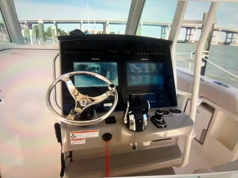 Slide: The Image of 2020 Boston Whaler 380 Outrage helm with dual screens and steering wheel. - 14