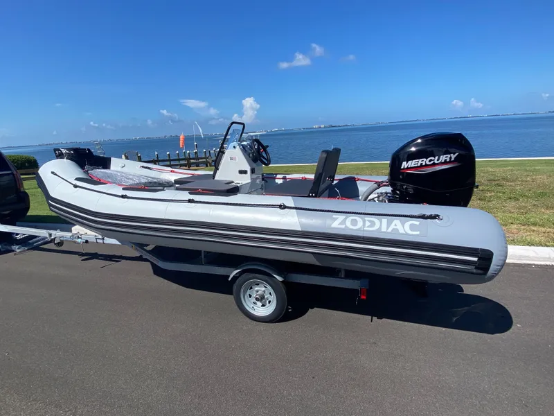 The Image of 2024 Zodiac Open 4.8 boat with Mercury engine on trailer by the waterfront. - 0