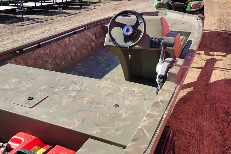 Slide: The Image of 2024 Tracker Grizzly 1648 SC boat with camouflage interior and steering console. - 3