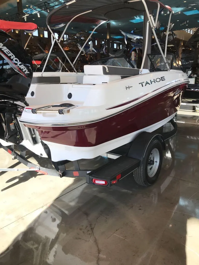 Slide: The Image of 2024 Tahoe 185 S boat in showroom, featuring sleek design and maroon accents. - 4