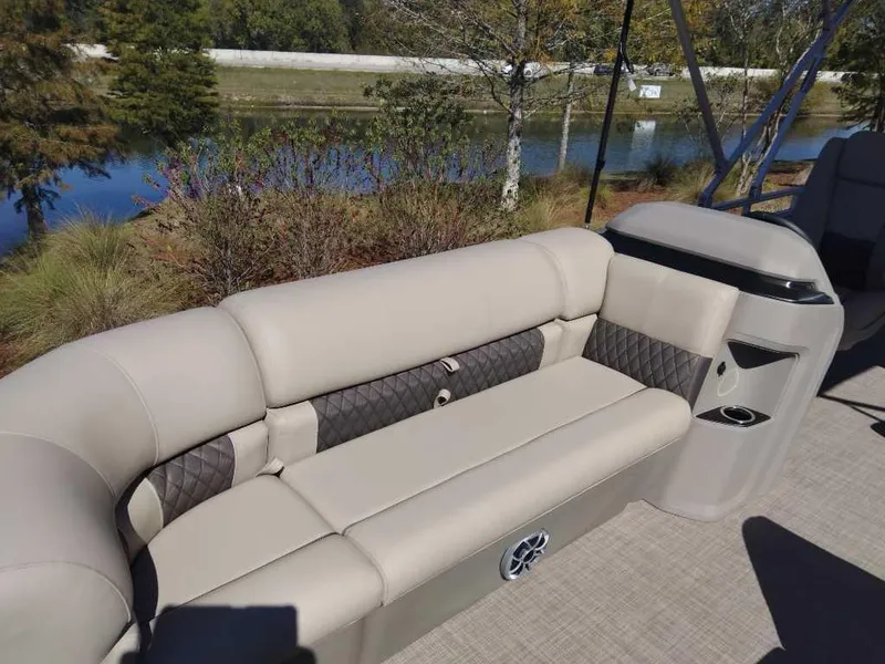 Slide: The Image of 2024 Sun Tracker Party Barge 20 DLX pontoon boat seating area by the water. - 11