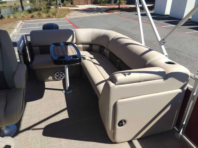 Slide: The Image of 2024 Sun Tracker Party Barge 20 DLX interior with beige seating and table. - 14