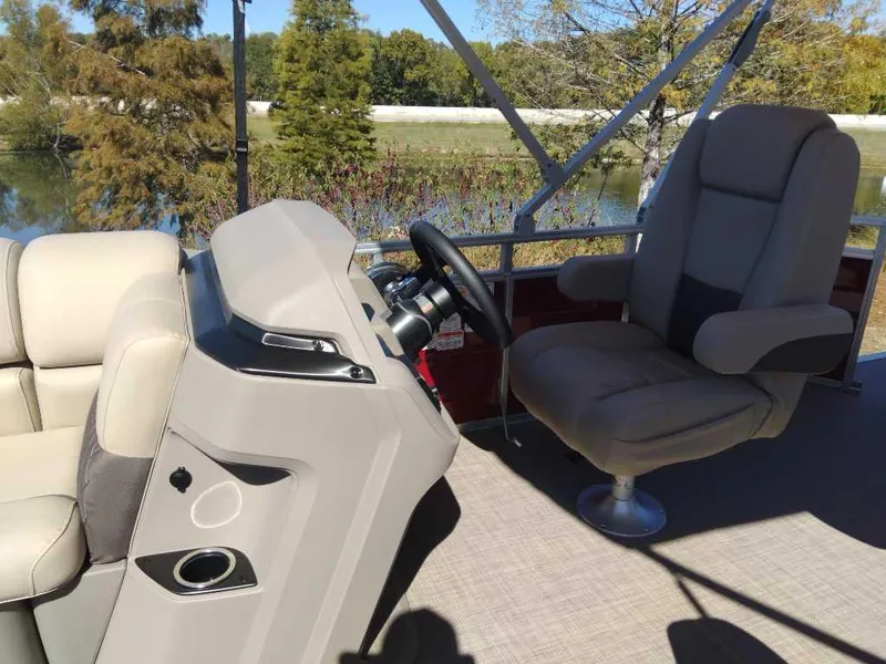 Slide: The Image of 2024 Sun Tracker Party Barge 20 DLX interior with steering console and seating. - 16