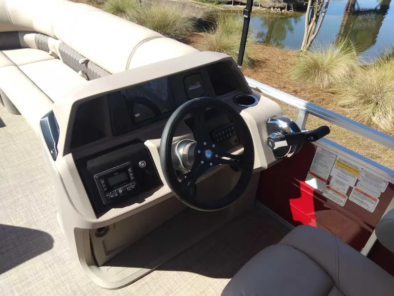 Slide: The Image of 2024 Sun Tracker Party Barge 20 DLX helm with steering wheel and control panel. - 17