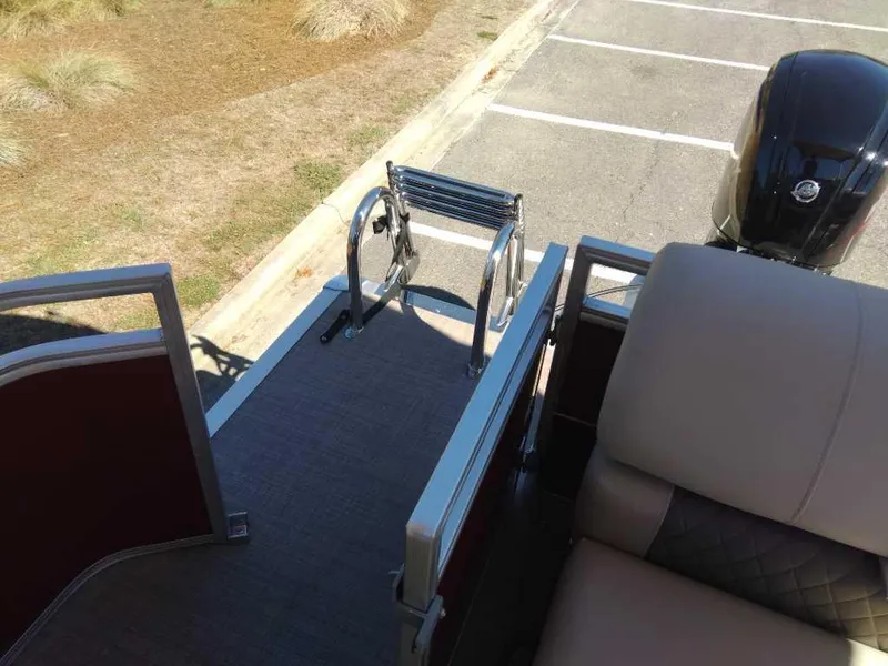 Slide: The Image of 2024 Sun Tracker Party Barge 20 DLX rear deck with boarding ladder and outboard motor. - 19