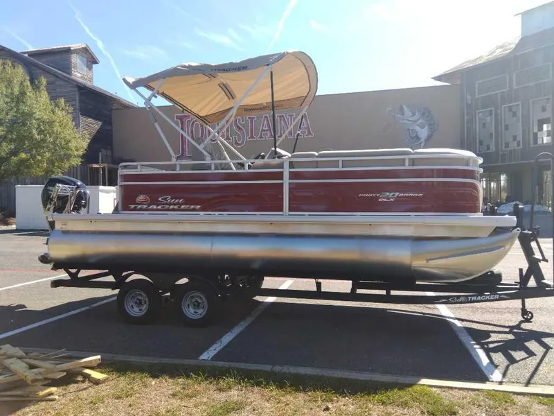 Slide: The Image of 2024 Sun Tracker Party Barge 20 DLX pontoon boat on trailer in parking lot. - 8