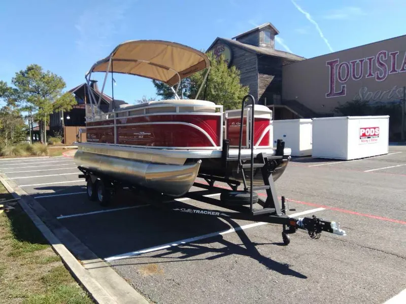 Slide: The Image of 2024 Sun Tracker Party Barge 20 DLX pontoon boat on trailer in parking lot. - 9