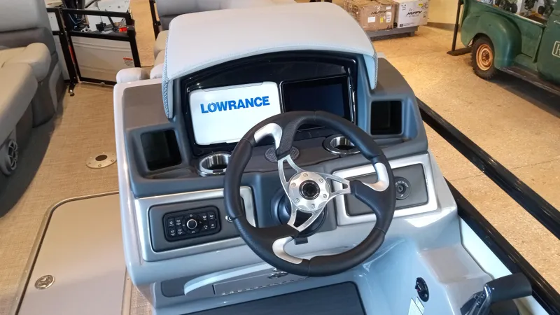 Slide: The Image of 2024 Regency 230 DL3 boat dashboard with Lowrance navigation system and steering wheel. - 3