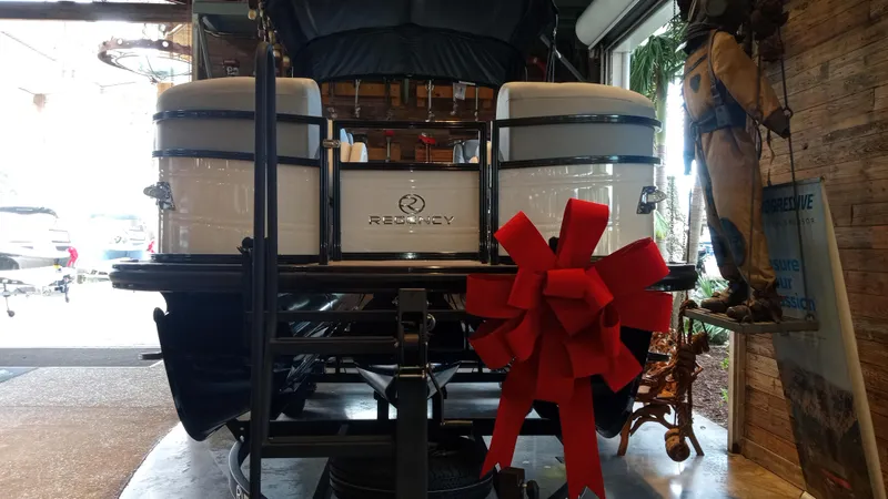 Slide: The Image of 2024 Regency 230 DL3 boat with a red bow on display in a showroom. - 5