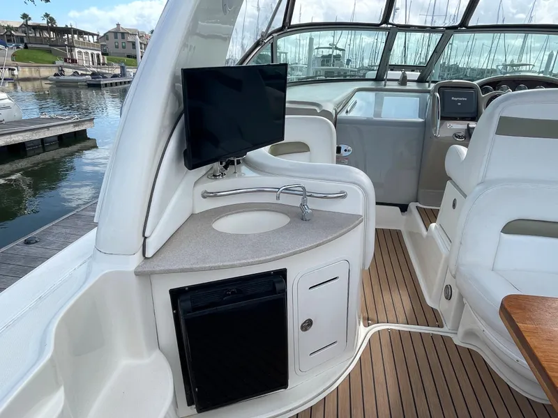 Slide: The Image of 2006 Sea Ray 320 Sundancer interior with sink, TV, and seating area. - 13