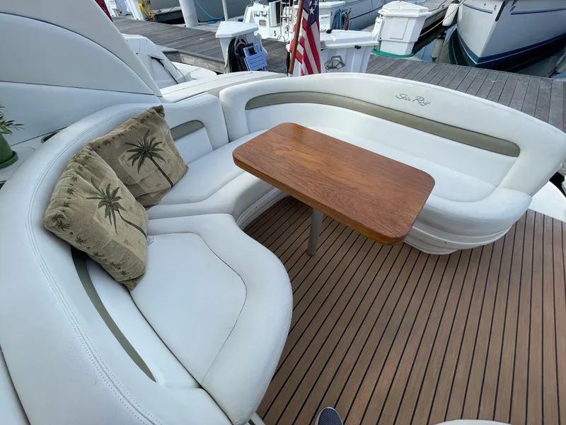 Slide: The Image of 2006 Sea Ray 320 Sundancer boat interior with white seating and wooden table. - 14