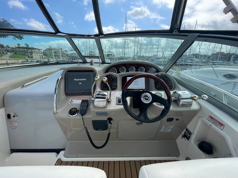 Slide: The Image of 2006 Sea Ray 320 Sundancer helm with Raymarine electronics and wood steering wheel. - 16