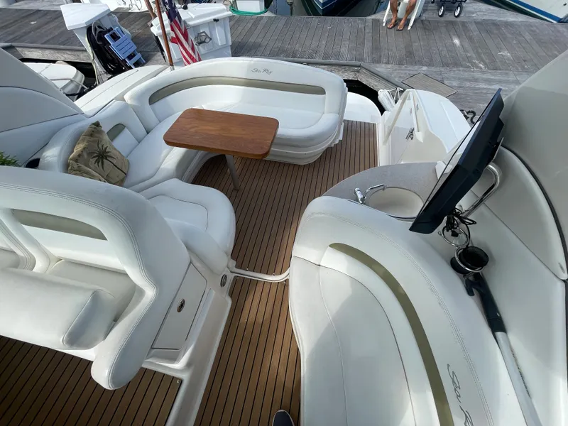 Slide: The Image of 2006 Sea Ray 320 Sundancer boat interior with white seating and wooden table. - 21