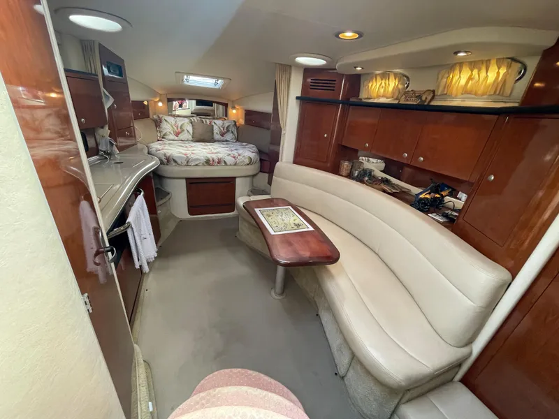 Slide: The Image of 2006 Sea Ray 320 Sundancer cabin interior with seating, table, and bed. - 25