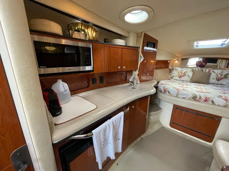 Slide: The Image of 2006 Sea Ray 320 Sundancer interior with kitchenette and cozy sleeping area. - 27