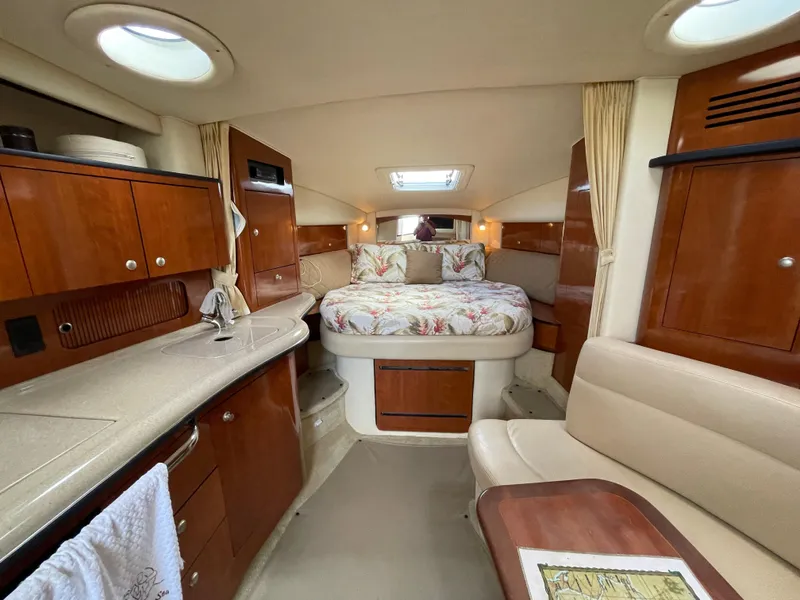 Slide: The Image of Interior of 2006 Sea Ray 320 Sundancer yacht with bed, kitchenette, and seating area. - 28