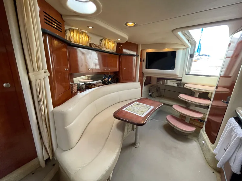 Slide: The Image of Luxurious interior of 2006 Sea Ray 320 Sundancer yacht with curved seating and wooden cabinetry. - 29