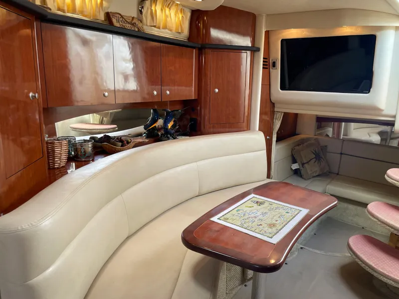 Slide: The Image of Interior of 2006 Sea Ray 320 Sundancer with leather seating, wooden cabinets, and TV. - 30