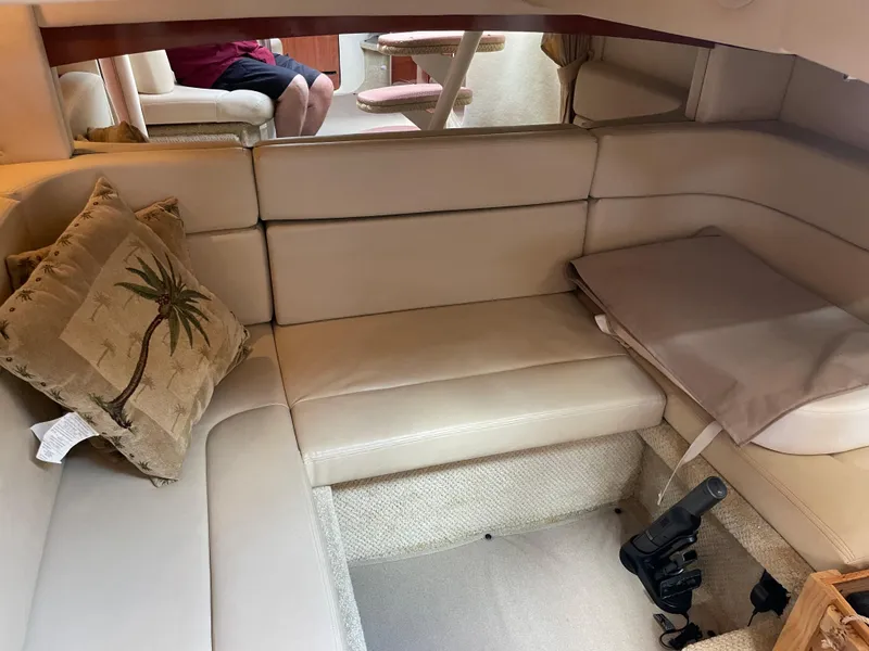 Slide: The Image of 2006 Sea Ray 320 Sundancer interior with beige leather seating and palm tree pillow. - 32