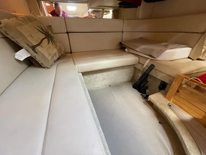 Slide: The Image of Interior of 2006 Sea Ray 320 Sundancer with beige seating and palm tree pillow. - 33