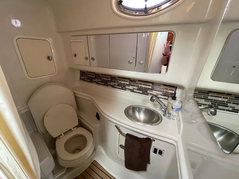 Slide: The Image of 2006 Sea Ray 320 Sundancer bathroom with toilet, sink, and storage cabinets. - 36