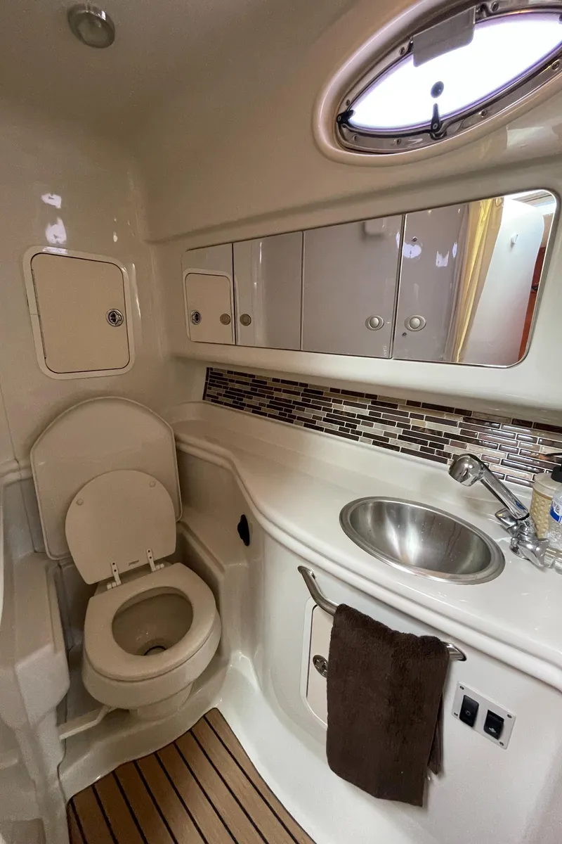 Slide: The Image of 2006 Sea Ray 320 Sundancer bathroom with sink, toilet, and storage cabinets. - 39