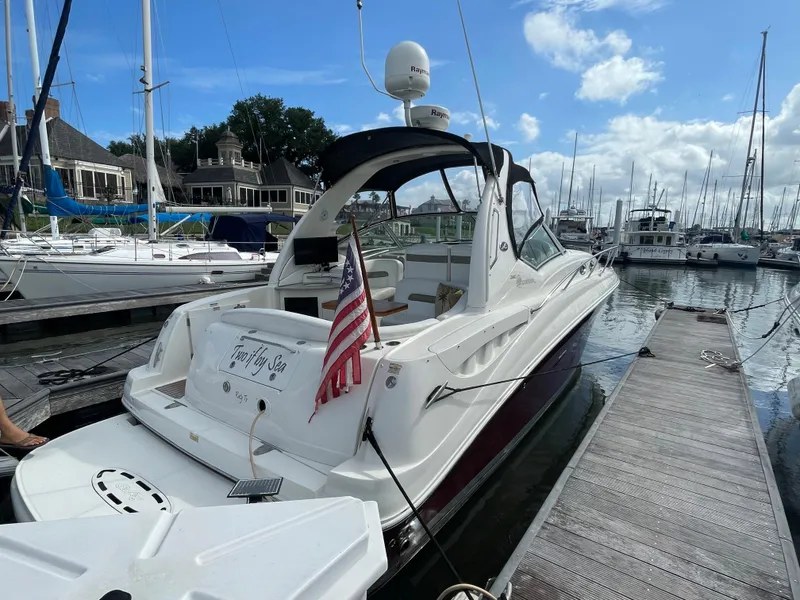 Slide: The Image of 2006 Sea Ray 320 Sundancer docked at a marina with American flag. - 6